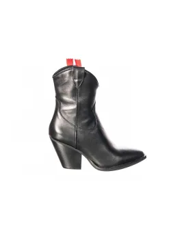 bottine western à talon biseauté, sur sa robe de cuir noir et son liceret rouge.