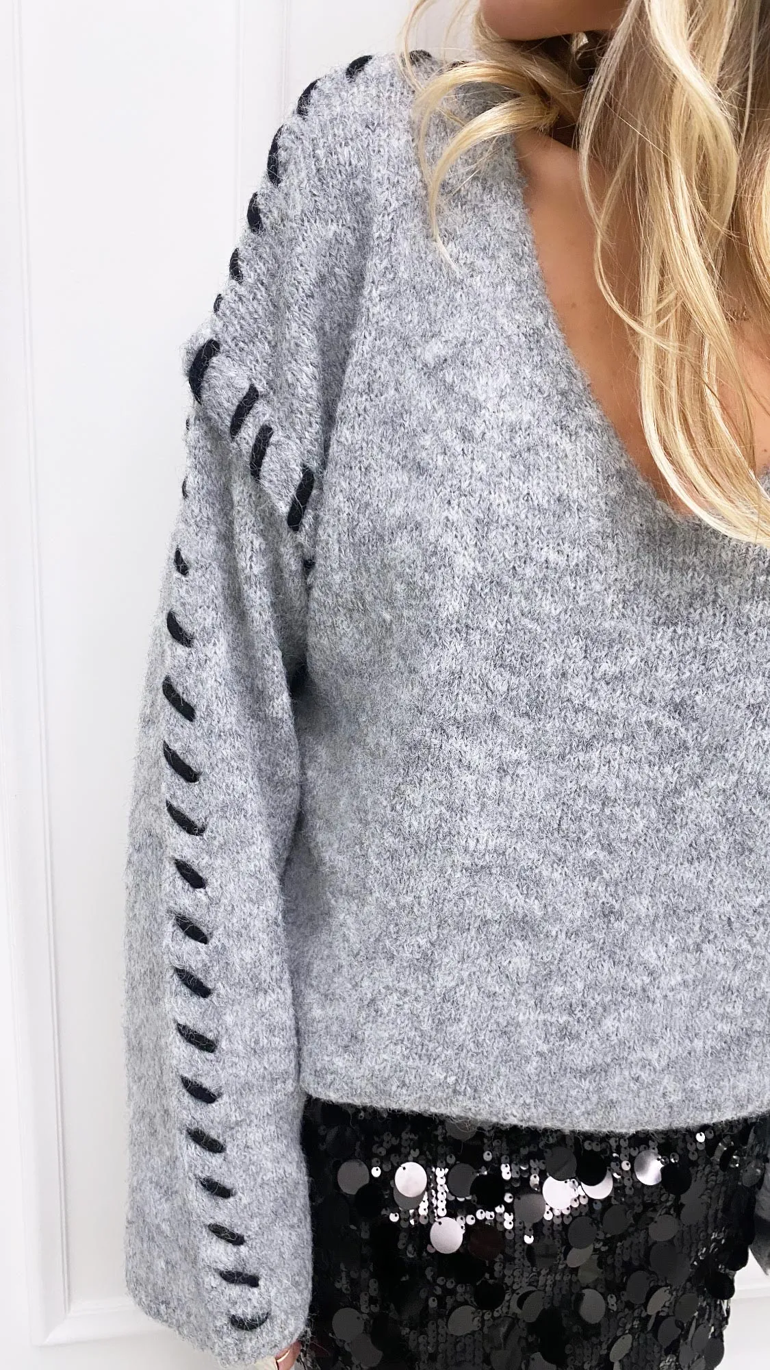 Pull gris surpiqûres noires col v